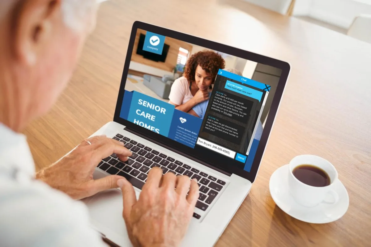 a senior man looking at senior living communities on his laptop with a cup of coffee on his desk